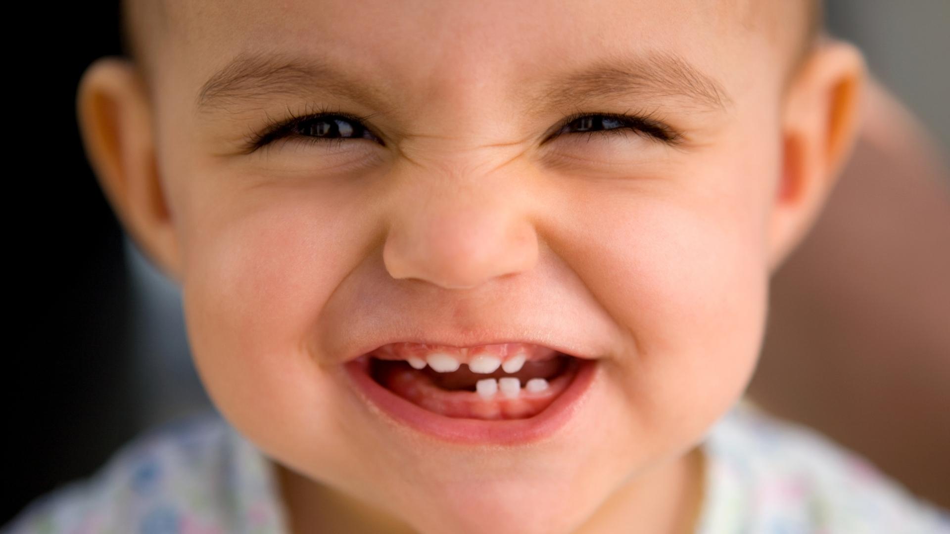 Niño pequeño mostrando sus dientes de leche.